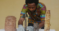 Benin bronzes looted in the past and returned to Nigeria are examined during a handing over ceremony