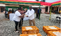 Volta Regional Minister James Gunu is seen handing over the chicks