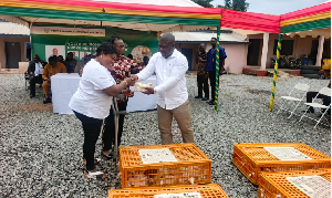 Volta Regional Minister James Gunu is seen handing over the chicks