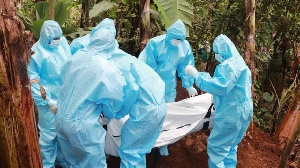 Public health officials bury a person who died of Covid-19 at Antuanthenge village in Meru County