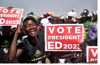 A ZANU-PF supporter holds a sign encouraging people to vote for President Emmerson Mnangagwa