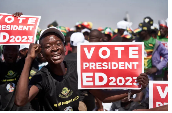 A ZANU-PF supporter holds a sign encouraging people to vote for President Emmerson Mnangagwa