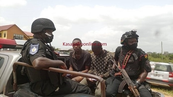 The suspected killers in a car with policemen