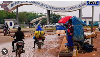 Motorcyclists ride by the entrance of the airport in Niamey, Niger, Tuesday, Aug. 8, 2023