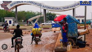 Motorcyclists ride by the entrance of the airport in Niamey, Niger, Tuesday, Aug. 8, 2023