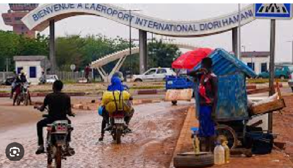 Motorcyclists ride by the entrance of the airport in Niamey, Niger, Tuesday, Aug. 8, 2023