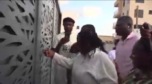 Paintsil's mum opening the gate of her new house