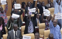 MPs in Parliament holding placards