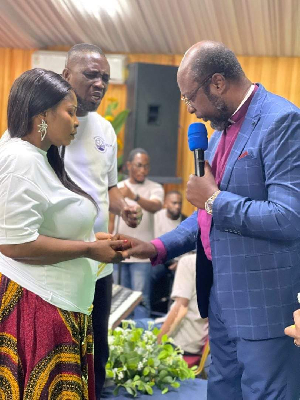 Dr. Ismaila Hans Awudu praying for some congregants during the service