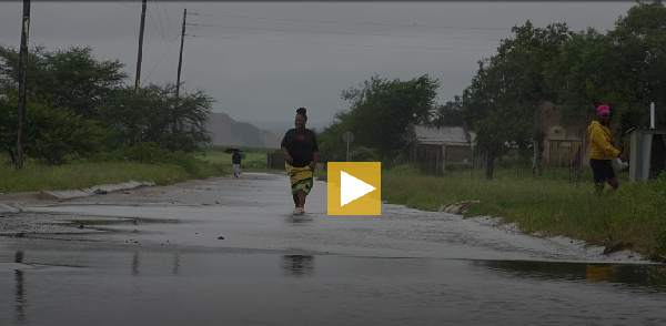 People walk through floodwaters in Nkomazi