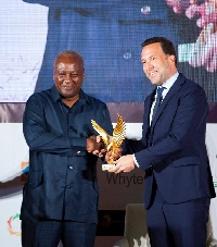 Saiid Masri [R] receiving his trophy from former president John Mahama