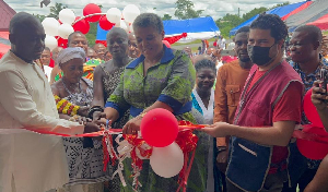 Gizella Agbotui-Tetteh (M) helping to cut the tape for the project