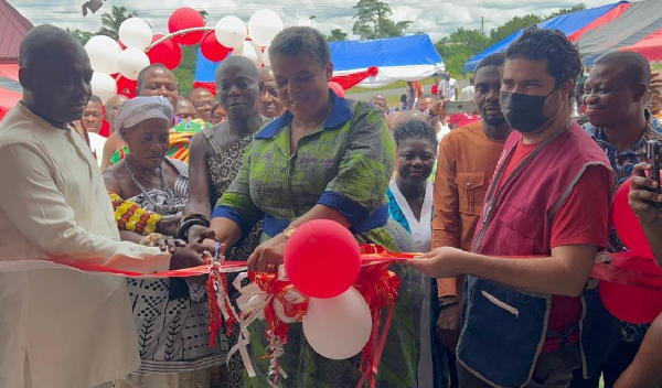 Gizella Agbotui-Tetteh (M) helping to cut the tape for the project