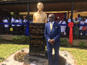 Prof. Kwabena Frimpong-Boateng standing beside his bust