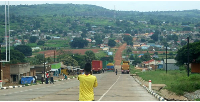 Trucks park at the Oraba border point in Koboko. Across the valley is Kaya town in South Sudan