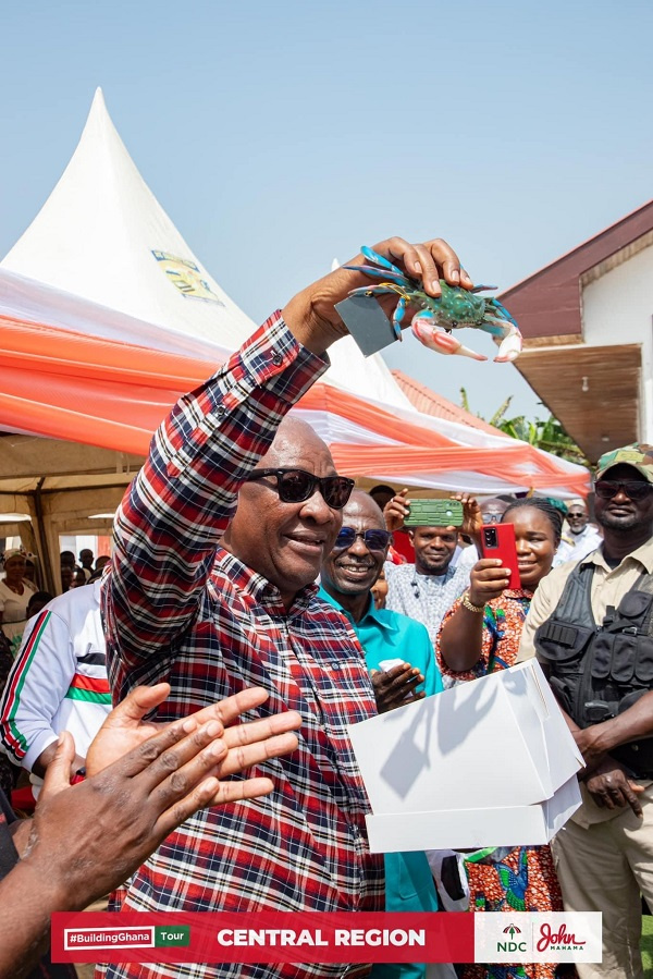 Former President, John Mahama holding a crab