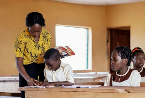 A female teacher helping a pupil in a classroom