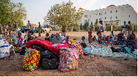Sudanese nationals sit outside the South Sudan People's Defense Forces (SSPDF) headquarters
