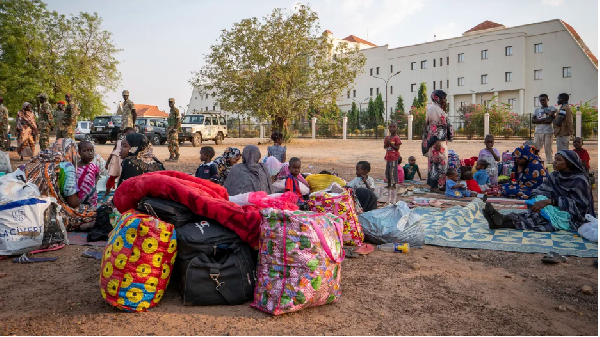 Sudanese nationals sit outside the South Sudan People's Defense Forces (SSPDF) headquarters