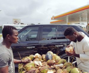 Sarkodie buying coconut by the road side