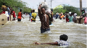 A man carries a sack through floodwater in Beledweyne (Hassan Ali Elmi/AFP/Getty Images)