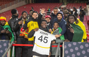Black Stars defender, Derrick Kohn taking a picture with fans after the Germany game