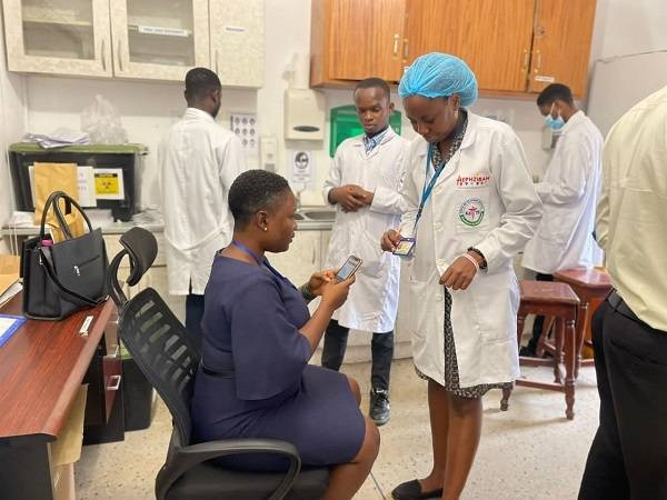 An official of APHC checking to verify the licence of one of the laboratory personnel