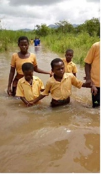 Some students walking through water to school