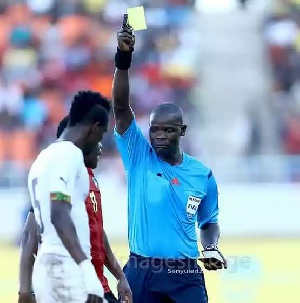 A Mozambican player booked after he hauled down John Boye