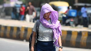 A woman in Delhi covers her head with a cloth to protect herself from the sun