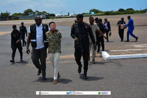 Robbery suspect Adinda-Akpo Abdou Moudjibou escorted by police officers upon arrival in Ghana