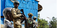 Members of the M23 rebel group stand guard as people attend a rally addressed by Corneille Nangaa