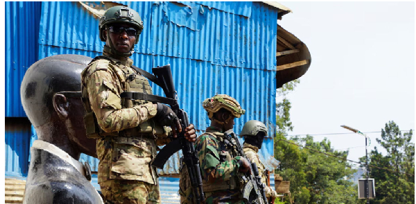 Members of the M23 rebel group stand guard as people attend a rally addressed by Corneille Nangaa