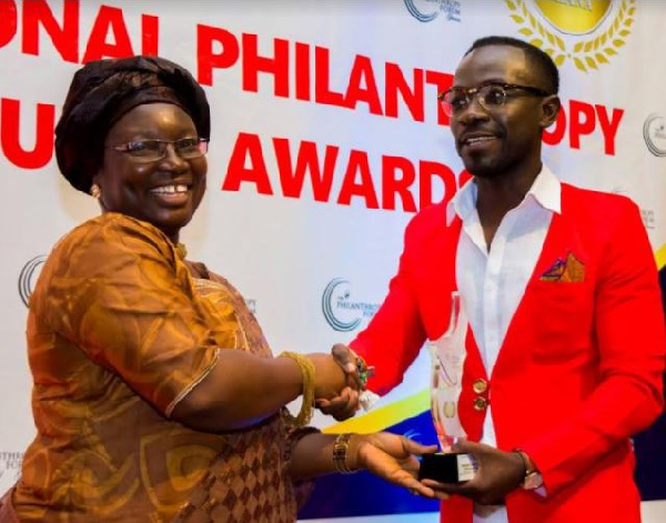 Okyeame Kwame receiving his award from Mrs.Diana Hopeson