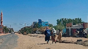 People walk along a deserted street in southern Khartoum
