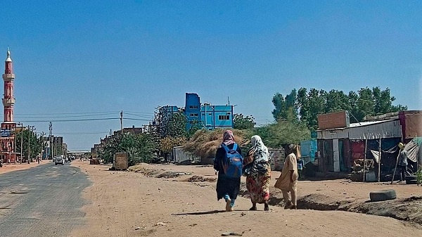 People walk along a deserted street in southern Khartoum