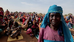 A Sudanese refugee who is seeking refuge in Chad waits with other refugees