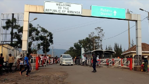 People walk past the Congo side of the Poids Lourd checkpoint at the border between Congo and Rwanda