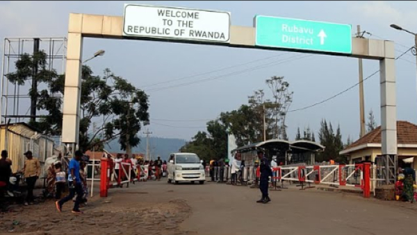 People walk past the Congo side of the Poids Lourd checkpoint at the border between Congo and Rwanda