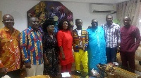 Okyeame Kwame (in Kente shirt) and his team in a pose with the Minister