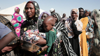Displaced women from El-Fasher queue for food aid at El-Afadh camp, Northern Sudan