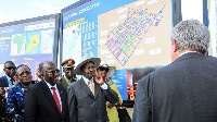 Tanzanian President John Magufuli and Ugandan President Yoweri Museveni stand in front the project