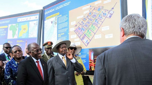 Tanzanian President John Magufuli and Ugandan President Yoweri Museveni stand in front the project