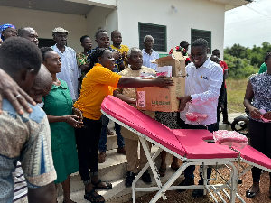 Edem Agbana is surrounded by the health staff and some of his team members during the donation