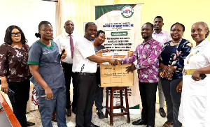 Workers at the Korle Bu Polyclinic (R) receiving a donation from the Drewgees Foundation (L)