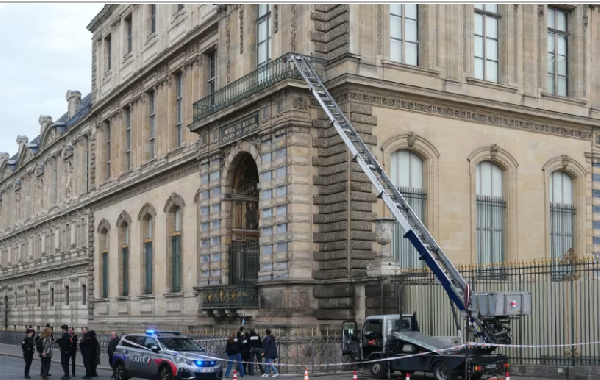 French police officers stand next to a furniture elevator used by robbers to enter the Louvre Museum