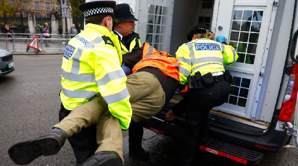 Police detain an activist during a protest by the group Just Stop Oil in London, England on October