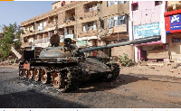 A damaged army tank is seen on a street a year into the war between the Sudanese army and the RSF