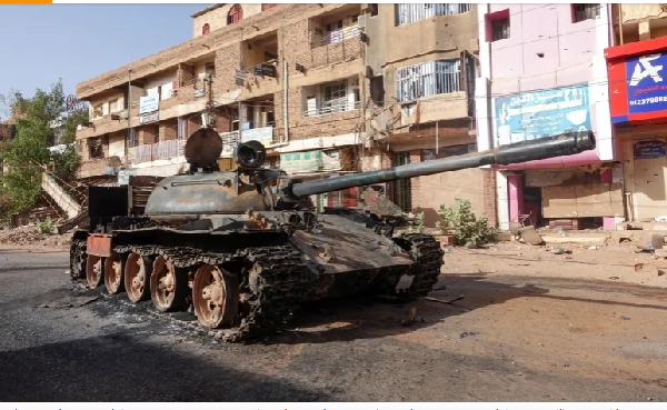 A damaged army tank is seen on a street a year into the war between the Sudanese army and the RSF