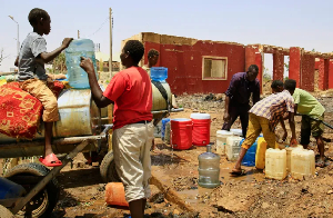 People fill containers with water at a distribution point during water outages in Khartoum, Sudan